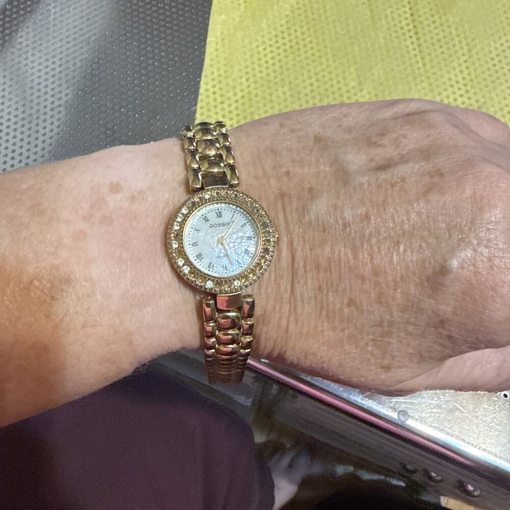 Gold-tone women's "Gossip" brand quartz wristwatch with a white mother-of-pearl